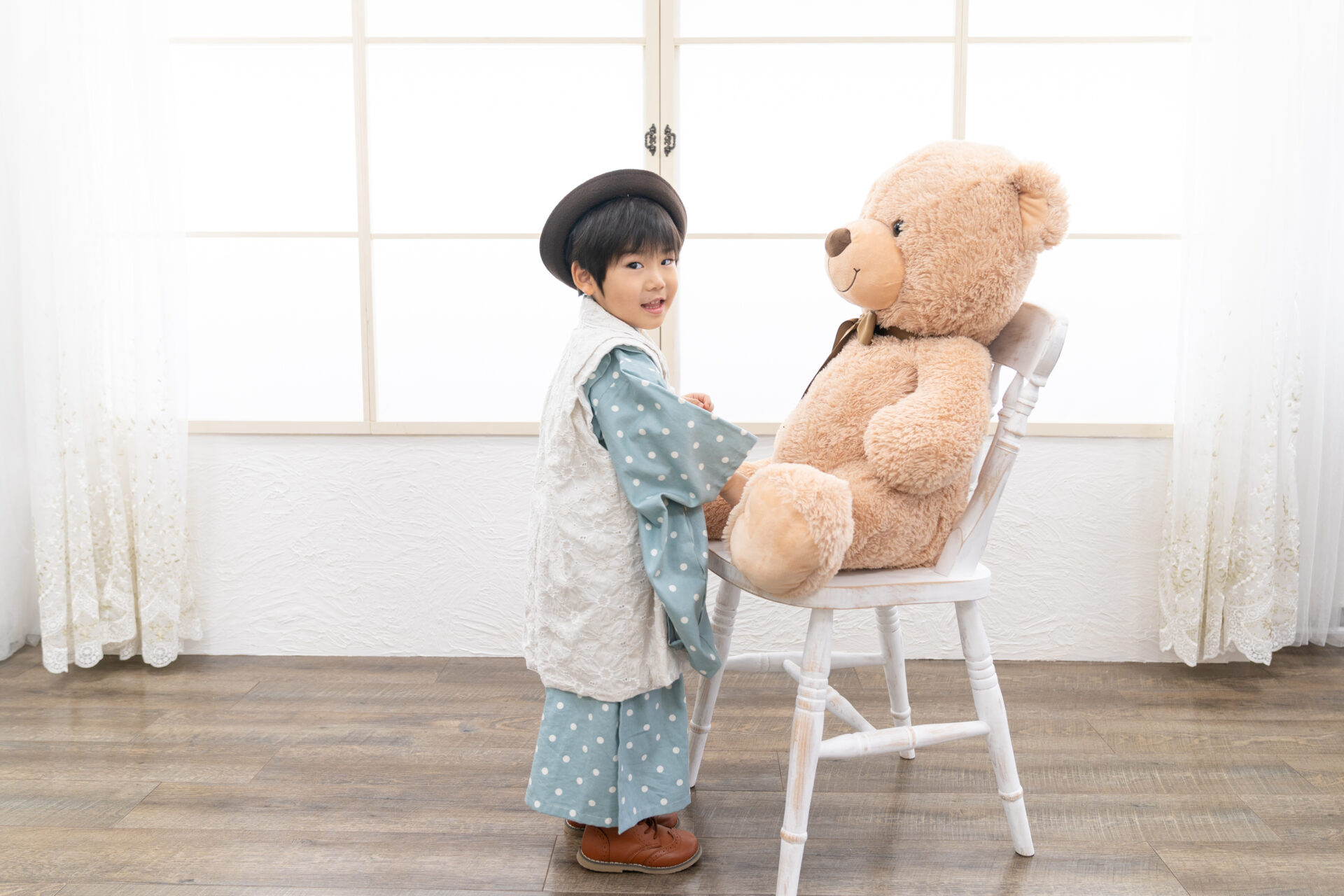 3歳男の子七五三写真。大きなクマと一緒にホワイトフレームの前で。